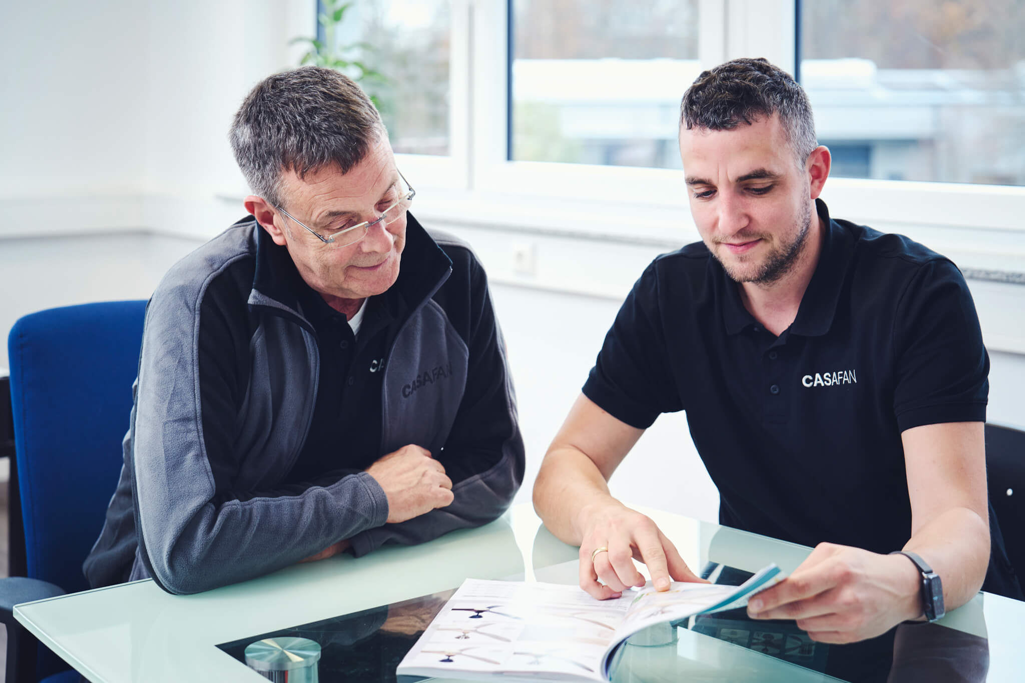 Zwei Männer schauen auf Dokumente auf einem Tisch
