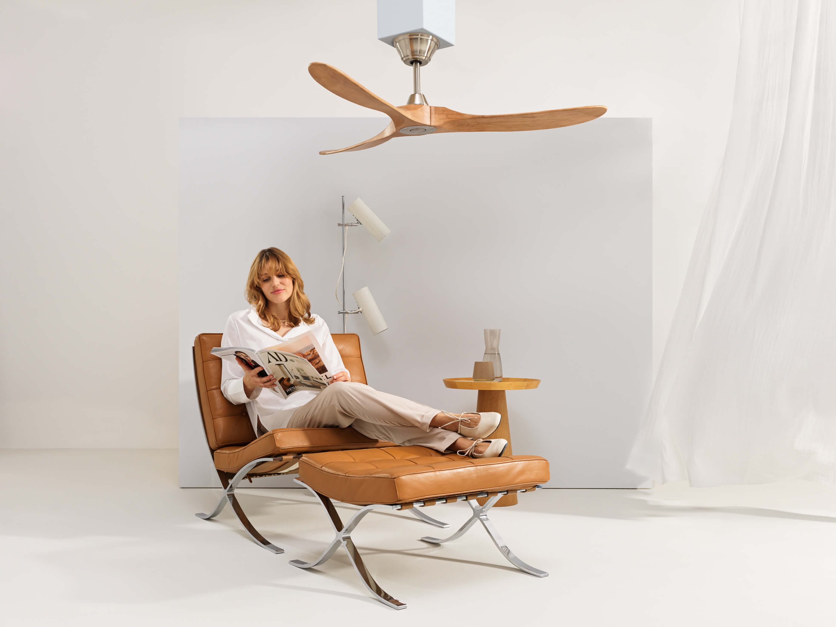 Eine Frau auf einer Couch, darüber ein Ventilator