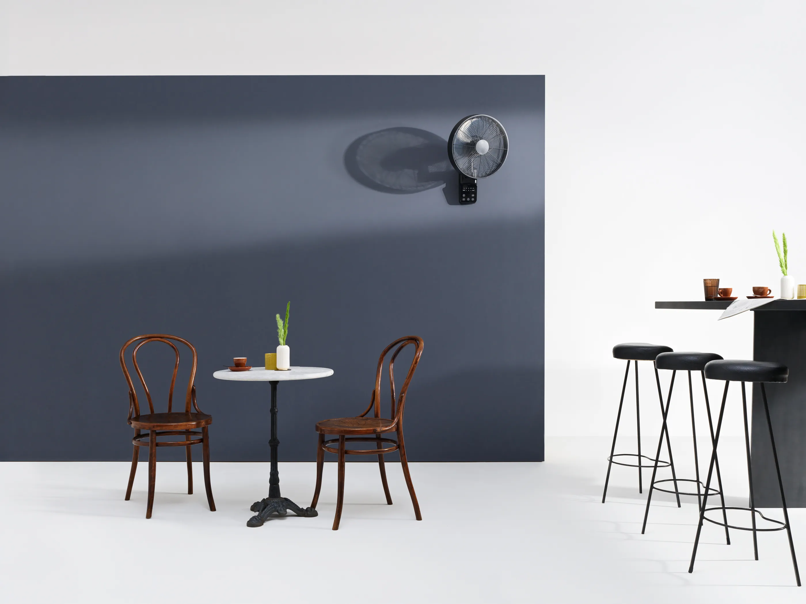 Café mit Tisch, Stühlen und Ventilator