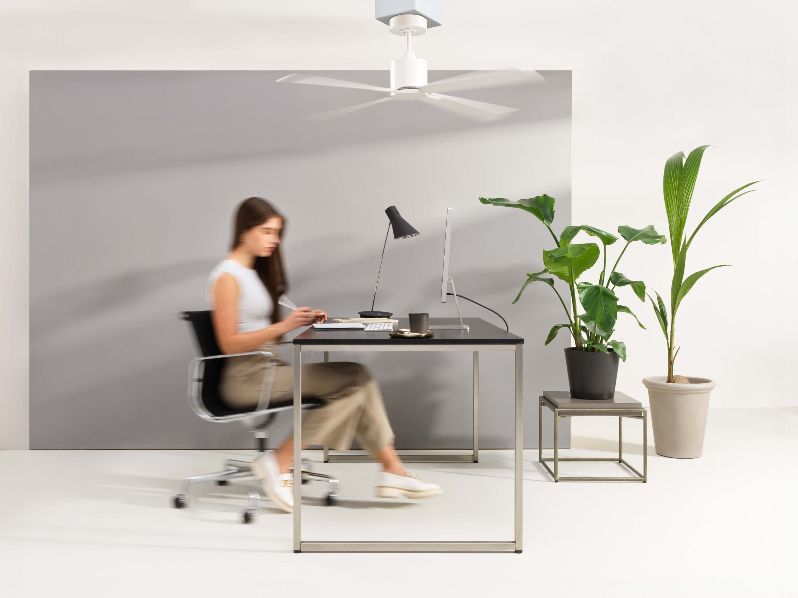 Büro mit Ventilator, Frau sitzt am Schreibtisch